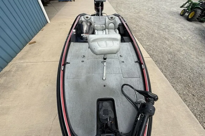 Slide: The Image of 2005 Triton TR 19 X fishing boat with gray seating and deck, parked on concrete. - 23