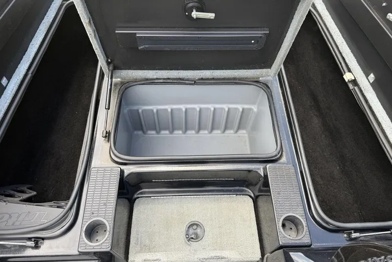 Slide: The Image of 2005 Triton TR 19 X boat storage compartment with open lid and cup holders. - 3