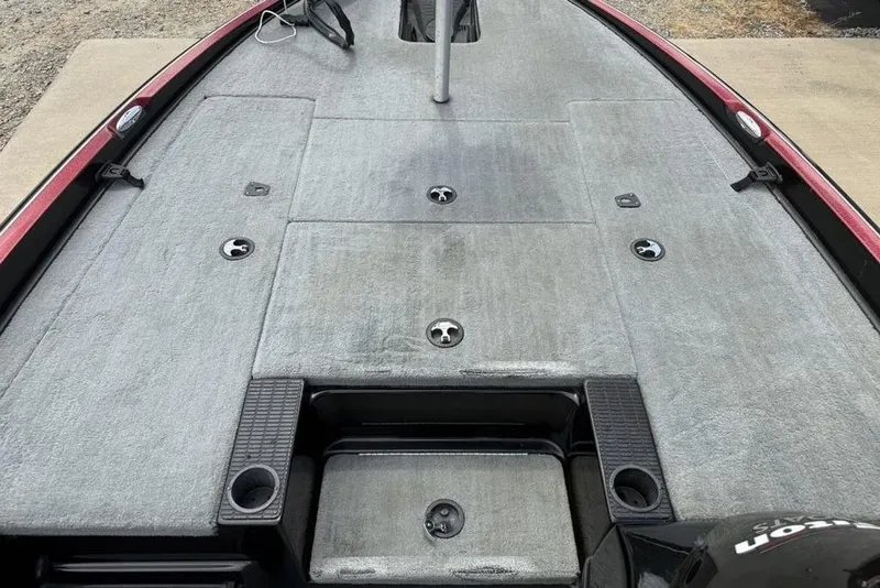 Slide: The Image of 2005 Triton TR 19 X boat deck with gray carpeting and storage compartments. - 7