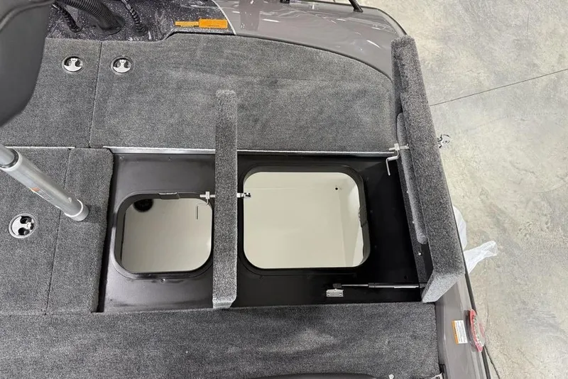 Slide: The Image of 2025 Skeeter ZXR20 boat storage compartments with open hatches on a carpeted deck. - 19