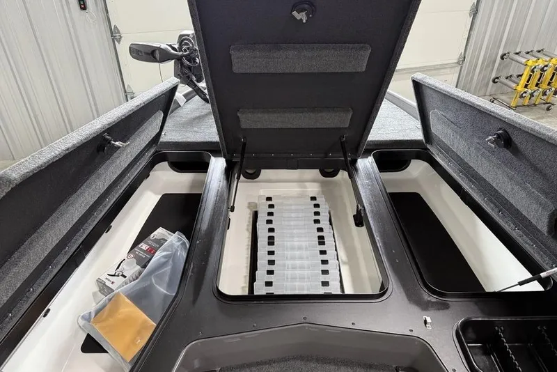Slide: The Image of 2025 Skeeter ZXR20 boat interior storage compartments open in a garage setting. - 5