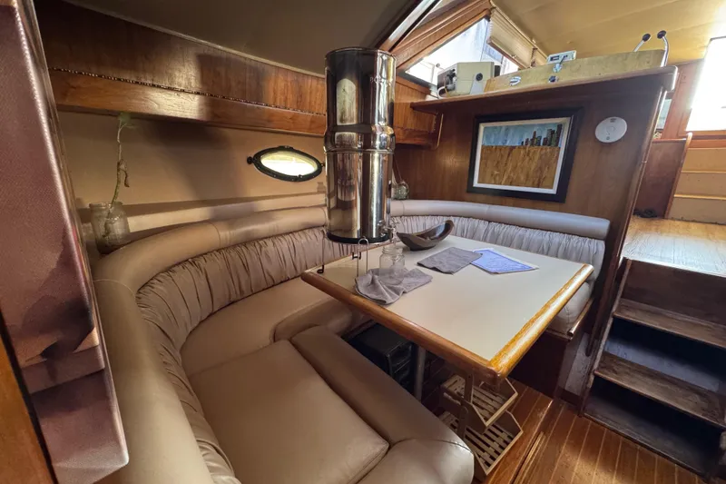 Slide: The Image of Cozy interior of a 1986 Californian 42 yacht with a dining area and wooden accents. - 10