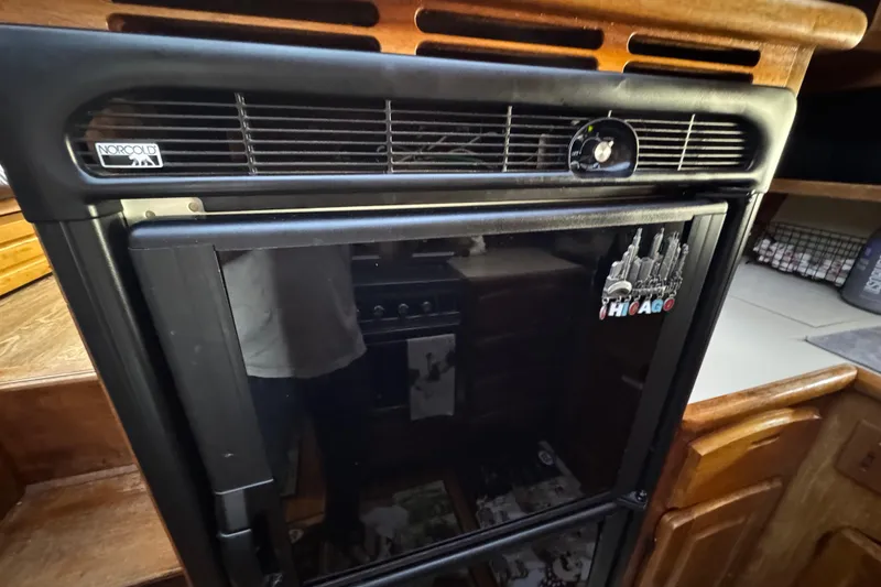 Slide: The Image of Norcold refrigerator in a 1986 Californian 42 yacht interior, featuring a Chicago magnet. - 11