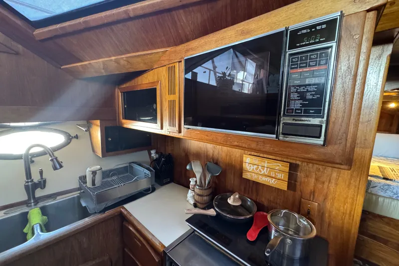 Slide: The Image of 1986 Californian 42 yacht kitchen with microwave, sink, and cookware. - 13