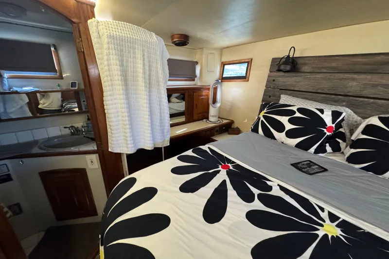 Slide: The Image of Cozy bedroom in 1986 Californian 42 yacht with floral bedding and compact bathroom. - 21