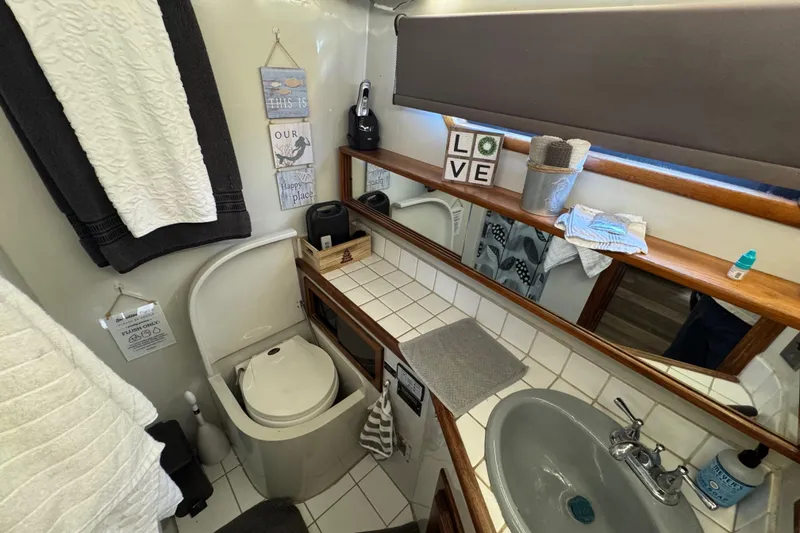 Slide: The Image of Bathroom interior of a 1986 Californian 42 yacht, featuring a sink, toilet, and decorative elements. - 22