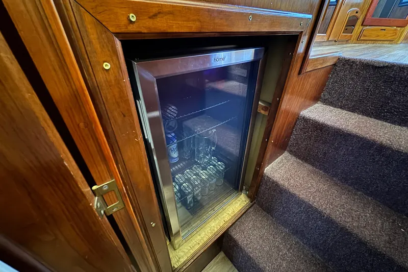 Slide: The Image of Mini fridge in 1986 Californian 42 yacht, built into wooden cabinetry beside carpeted stairs. - 25