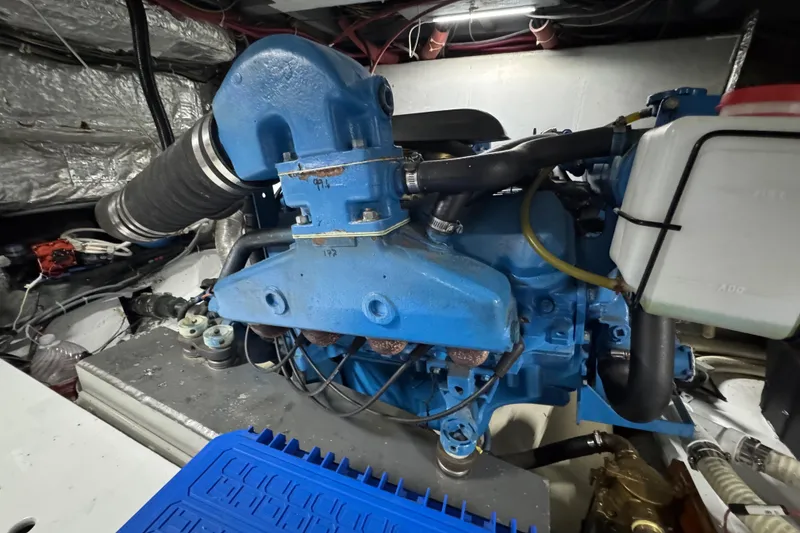 Slide: The Image of Engine room of a 1986 Californian 42 boat, featuring a blue marine engine. - 30