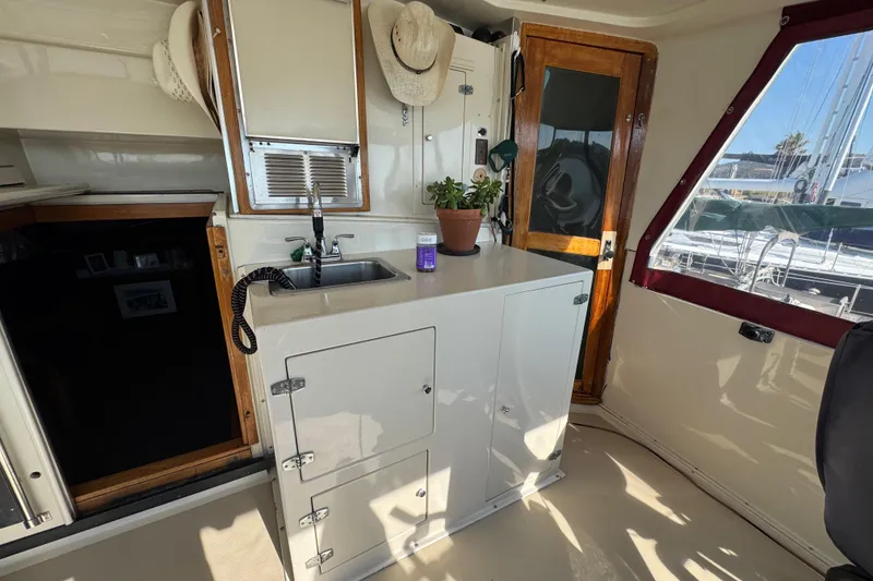 Slide: The Image of Interior of 1986 Californian 42 yacht with kitchenette, sink, and potted plant. - 47