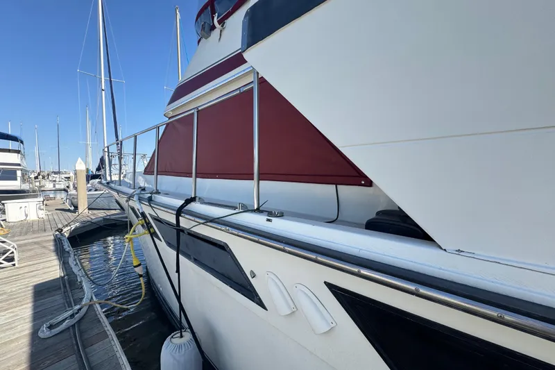 Slide: The Image of 1986 Californian 42 yacht docked at marina, featuring red accents and sleek design. - 6