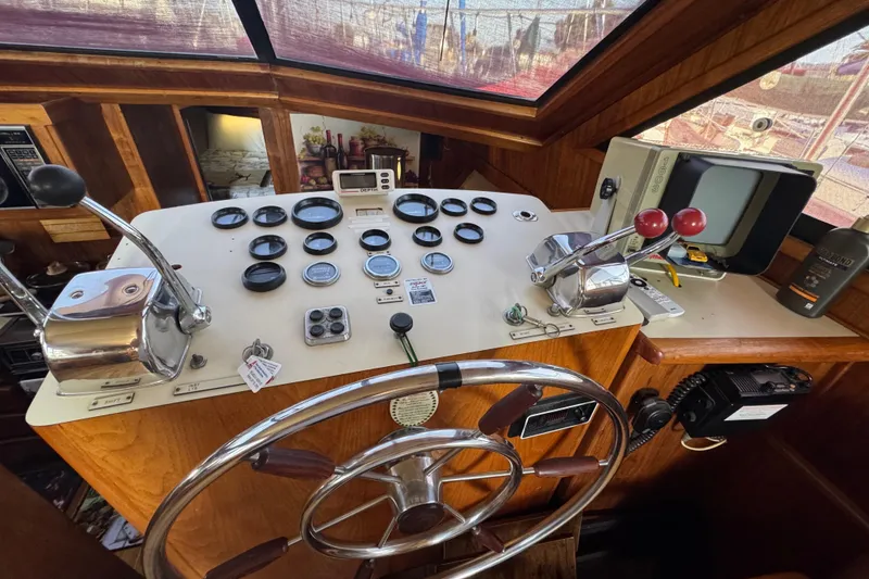 Slide: The Image of 1986 Californian 42 yacht helm with gauges, controls, and steering wheel in wooden cabin. - 7