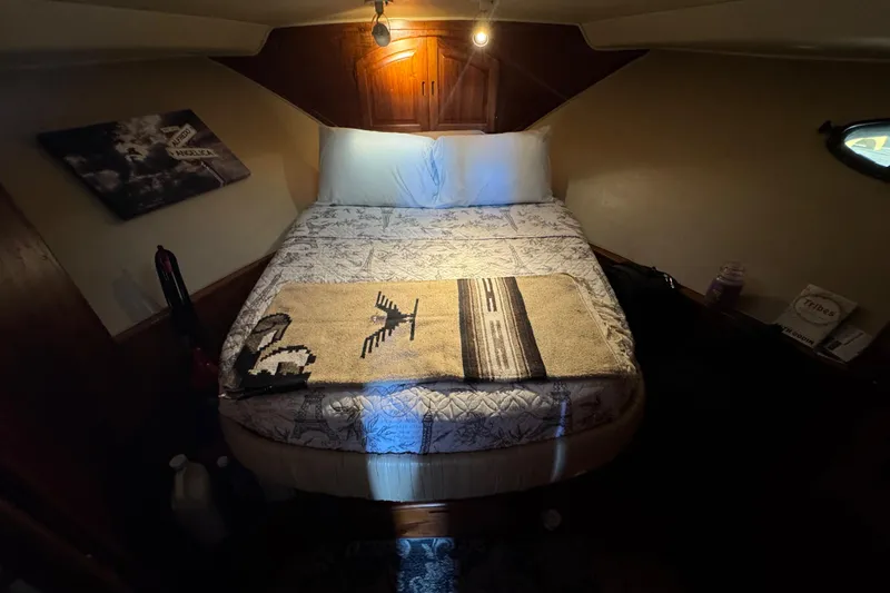 Slide: The Image of Cozy cabin bedroom in a 1986 Californian 42 yacht, featuring a neatly made bed. - 8