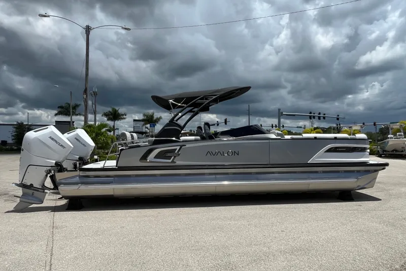 Slide: The Image of 2026 Avalon 2785 Excalibur LTD boat with twin Mercury 400hp engines, parked under cloudy skies. - 4