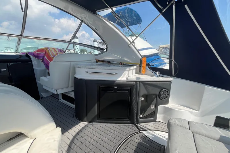 Slide: The Image of 2020 Rinker 290 EX boat interior with seating, kitchenette, and modern design. - 10
