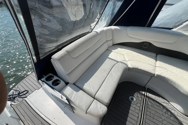Slide: The Image of 2020 Rinker 290 EX boat interior with white seating and cup holders. - 12