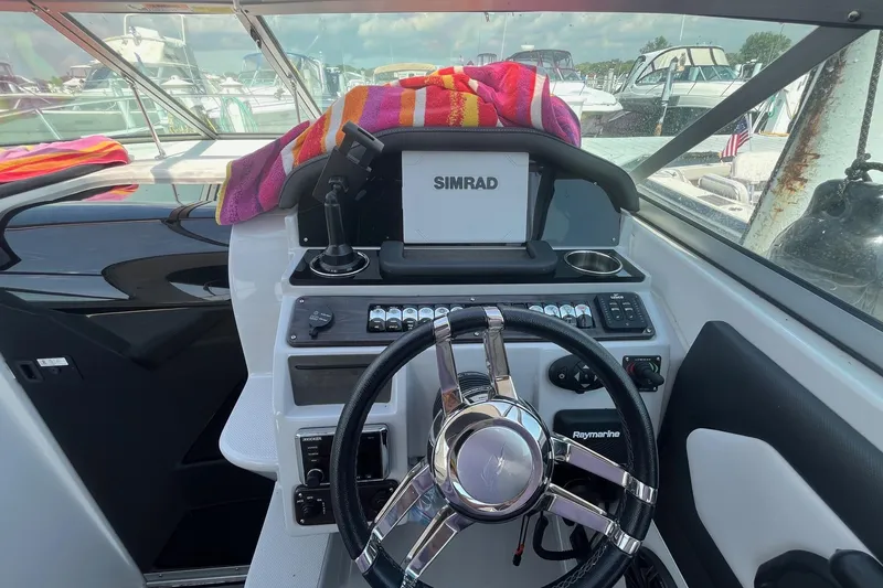 Slide: The Image of 2020 Rinker 290 EX boat helm with Simrad navigation system and Raymarine controls. - 13