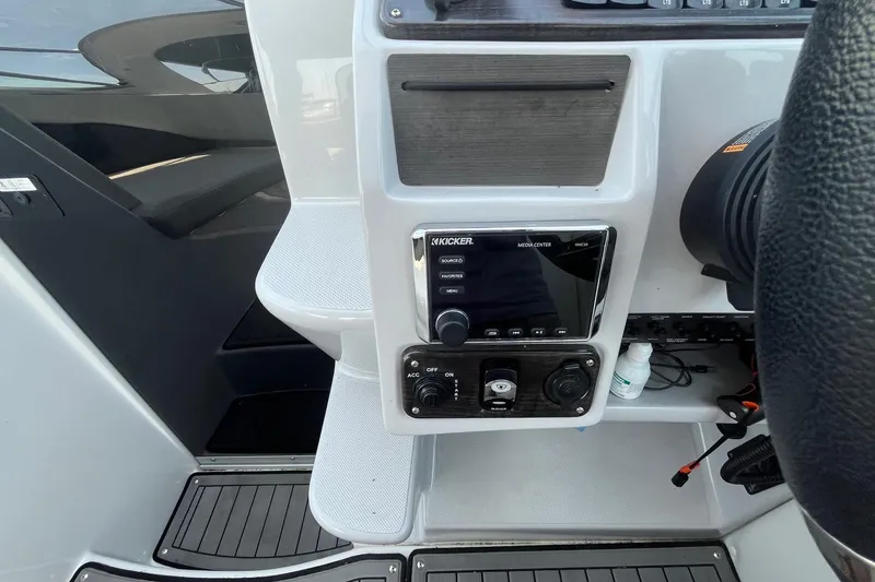 Slide: The Image of 2020 Rinker 290 EX boat dashboard with Kicker media center and controls. - 14
