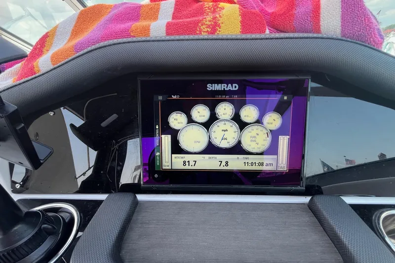 Slide: The Image of 2020 Rinker 290 EX boat dashboard with Simrad display and colorful towel. - 17