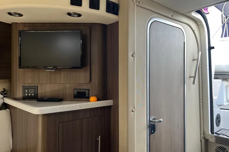 Slide: The Image of Interior of 2020 Rinker 290 EX boat with TV and modern cabinetry. - 18