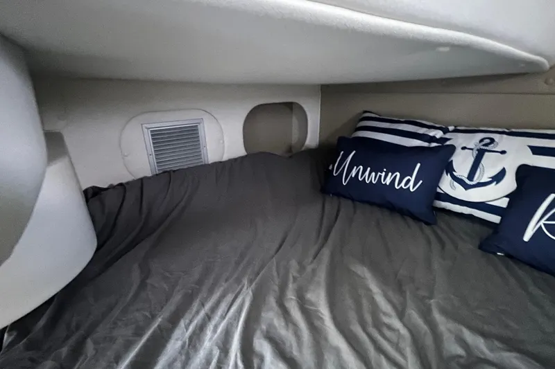 Slide: The Image of Cozy cabin interior of 2020 Rinker 290 EX with nautical-themed pillows. - 25