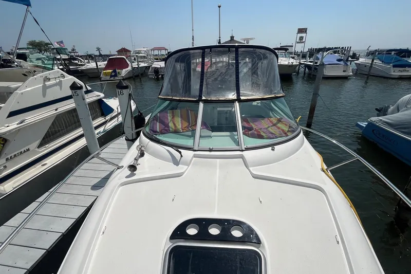 Slide: The Image of 2020 Rinker 290 EX boat docked at marina, surrounded by other vessels. - 3