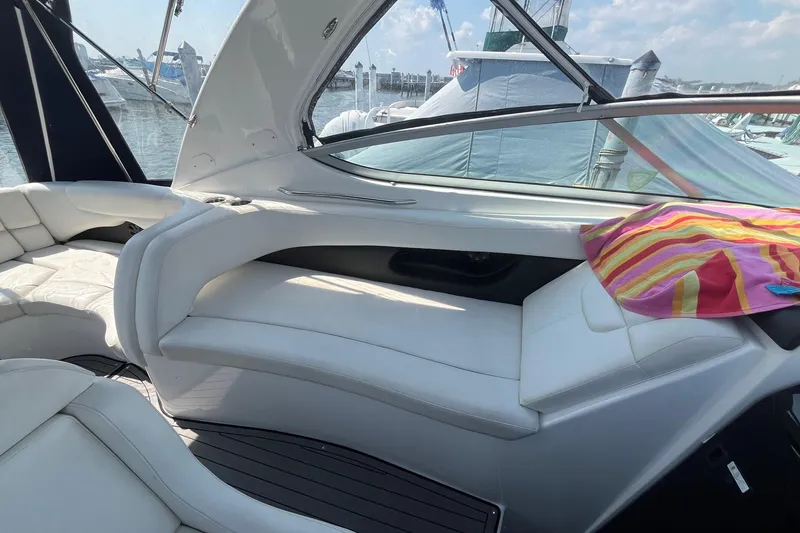 Slide: The Image of 2020 Rinker 290 EX boat interior with white seating and colorful towel. - 7
