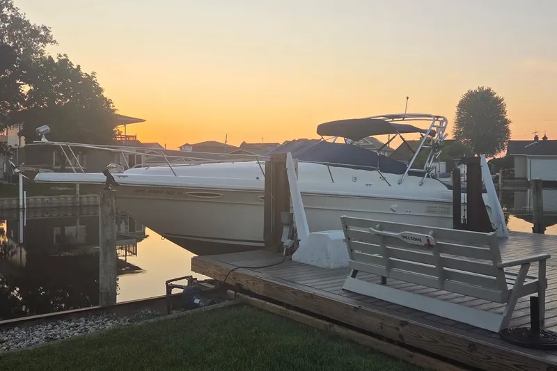 The Image of 1991 Sea Ray 300 Weekender docked at sunset, serene waterfront setting. - 0
