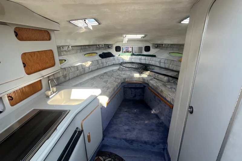 Slide: The Image of Interior of a 1991 Sea Ray 300 Weekender boat with kitchenette and seating area. - 11