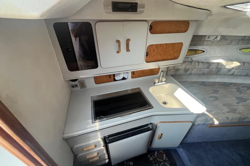 Slide: The Image of Interior of 1991 Sea Ray 300 Weekender boat with kitchenette and seating area. - 12