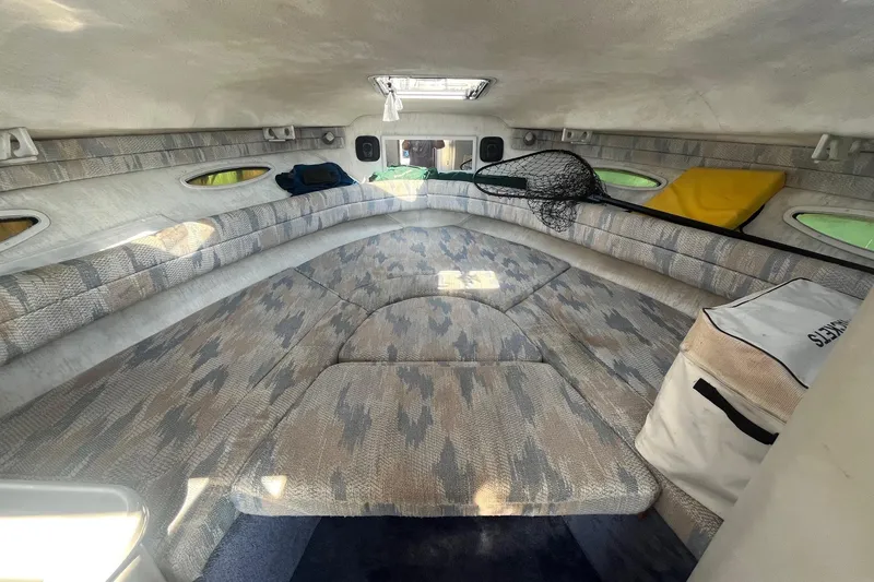 Slide: The Image of 1991 Sea Ray 300 Weekender cabin interior with patterned upholstery and storage compartments. - 16