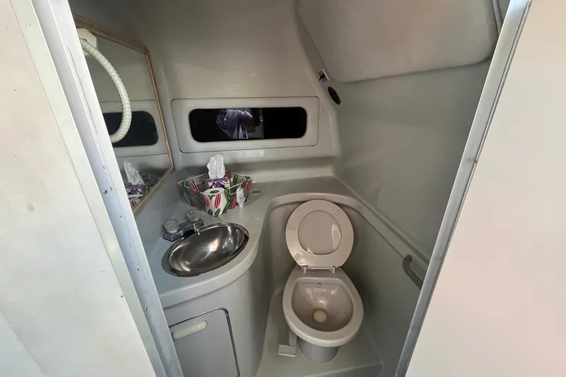 Slide: The Image of 1991 Sea Ray 300 Weekender boat bathroom with toilet, sink, and mirror. - 22