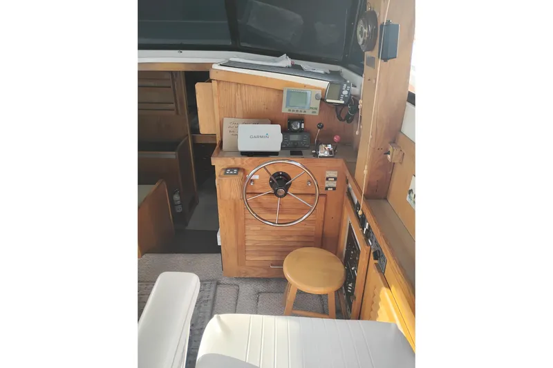 Slide: The Image of 1985 Mainship 34 Mk III helm with wooden dashboard, steering wheel, and navigation equipment. - 12