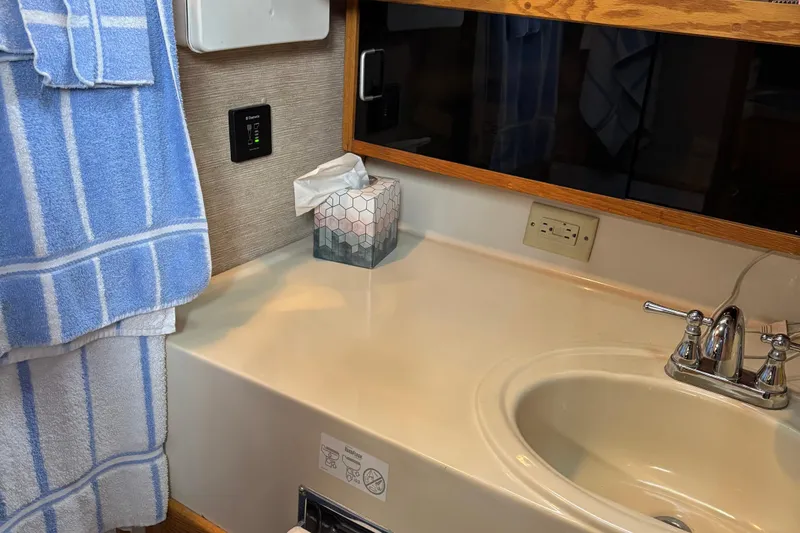 Slide: The Image of 1985 Mainship 34 III bathroom with sink, faucet, and blue towel. - 32