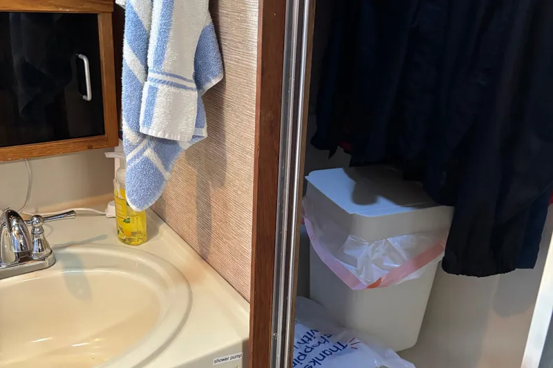 Slide: The Image of 1985 Mainship 34 III bathroom with sink, towel, and trash bin. - 35