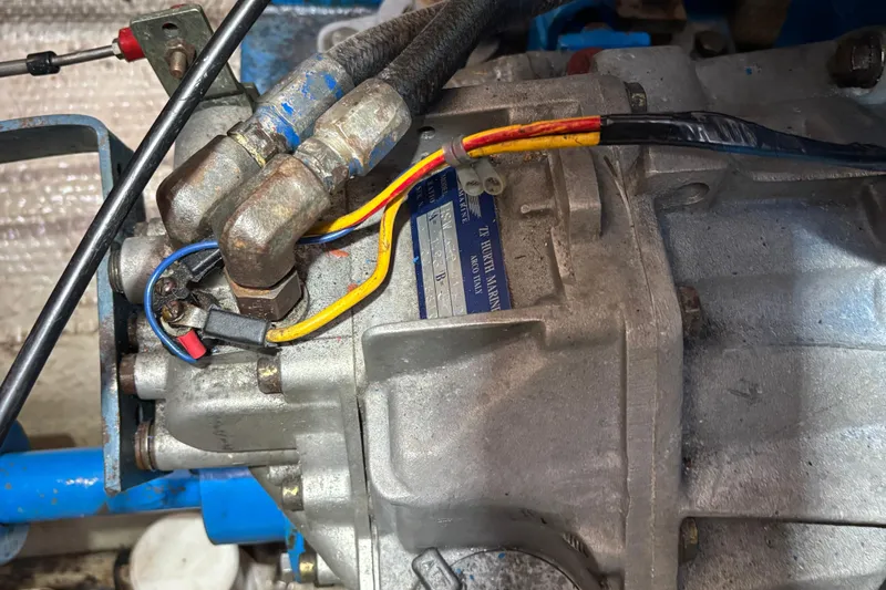 Slide: The Image of Engine components of a 1985 Mainship 34 III with visible wiring and metal fittings. - 48