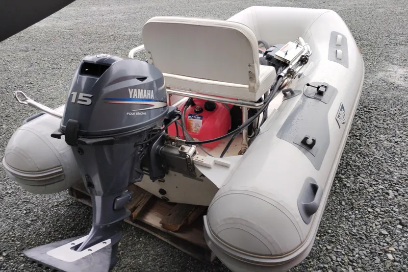Slide: The Image of Inflatable boat with Yamaha 15HP outboard motor on gravel surface. - 54