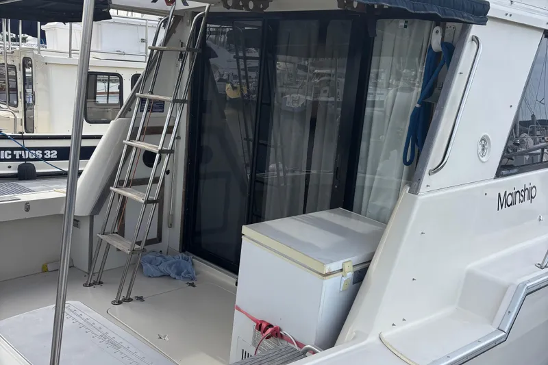 Slide: The Image of 1985 Mainship 34 III boat with ladder and deck, docked at marina. - 7