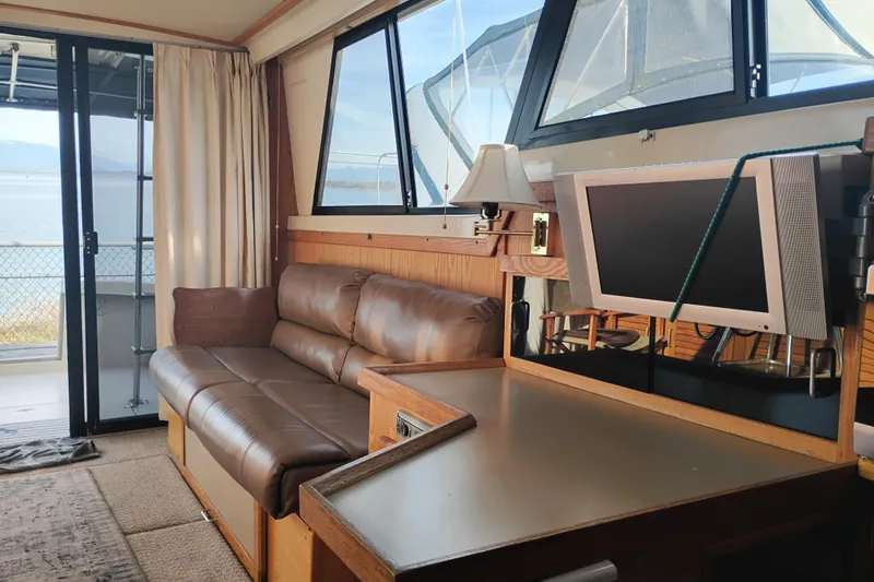 Slide: The Image of Interior of 1985 Mainship 34 Mk III with leather sofa and mounted TV. - 9