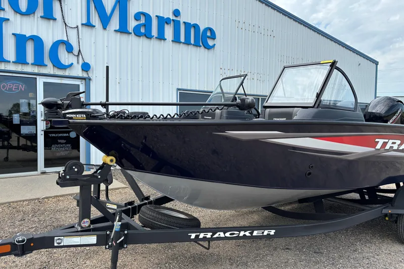 Slide: The Image of 2025 Tracker Targa V-18 Combo boat on trailer outside marine store. - 11