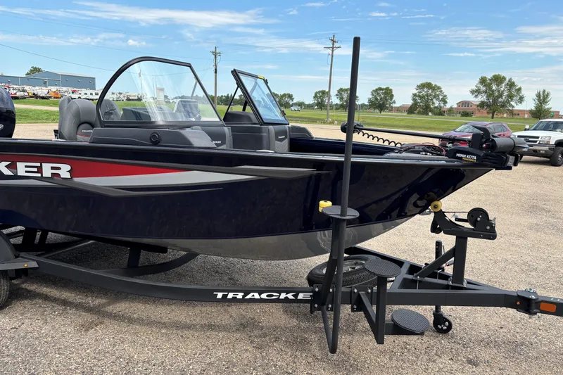 Slide: The Image of 2025 Tracker Targa V-18 Combo boat on trailer, parked outdoors under clear sky. - 13