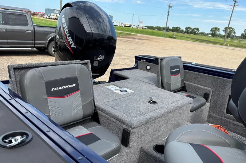 Slide: The Image of 2025 Tracker Targa V-18 Combo boat interior with Mercury engine, featuring gray and red seating. - 7