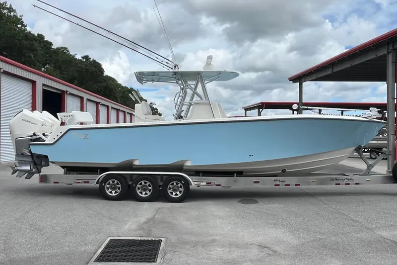 The Image of 2021 SeaVee 340Z boat on trailer, light blue hull, parked near storage units. - 1