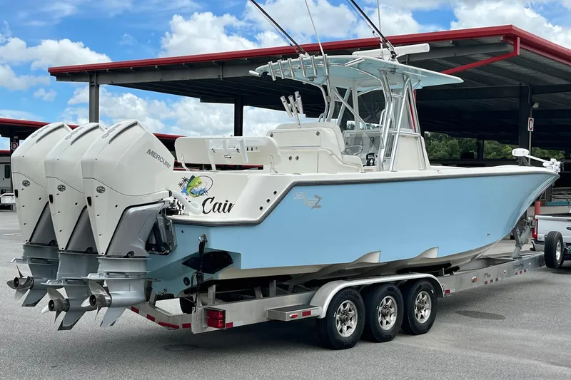 Slide: The Image of 2021 SeaVee 340Z boat with triple Mercury engines on a trailer, parked under a canopy. - 5