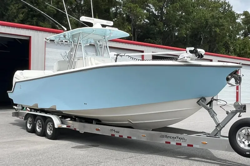 Slide: The Image of 2021 SeaVee 340Z boat on trailer, light blue hull, parked near storage units. - 6