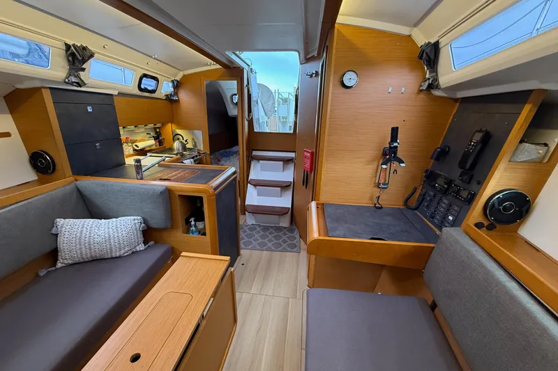 Slide: The Image of Interior of 2016 Jeanneau Sun Odyssey 349 sailboat, featuring cozy seating and navigation area. - 14