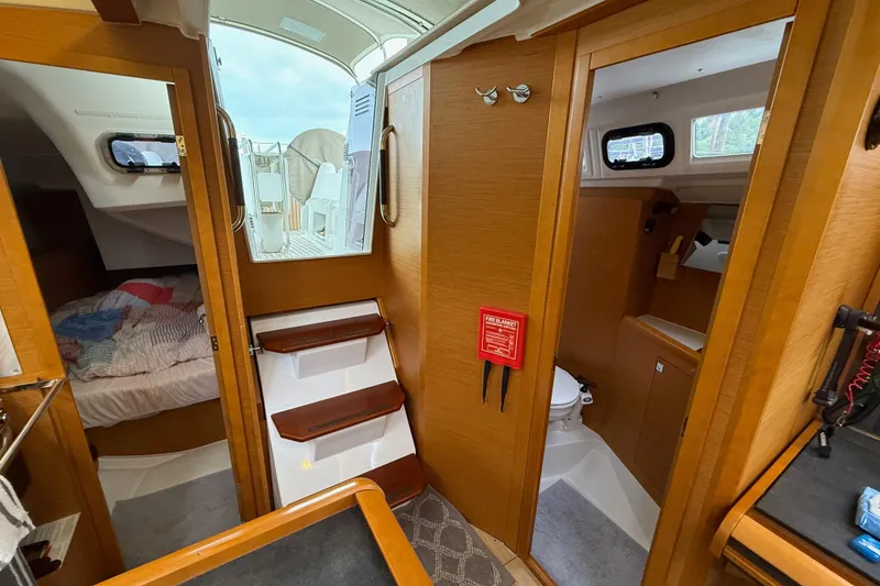 Slide: The Image of Interior of 2016 Jeanneau Sun Odyssey 349 sailboat, featuring cabin, stairs, and bathroom. - 17