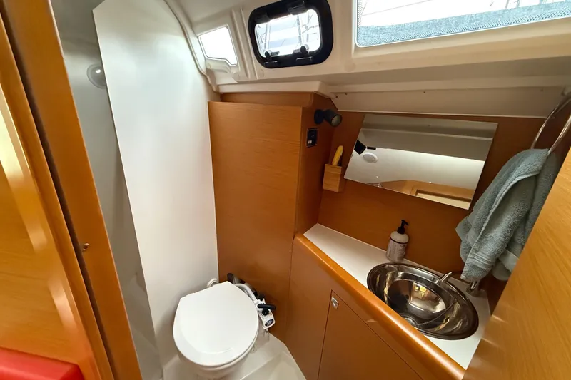 Slide: The Image of 2016 Jeanneau Sun Odyssey 349 bathroom with modern fixtures and wooden cabinetry. - 18
