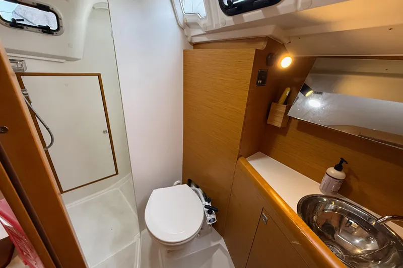 Slide: The Image of 2016 Jeanneau Sun Odyssey 349 bathroom with shower, toilet, sink, and wooden cabinetry. - 19