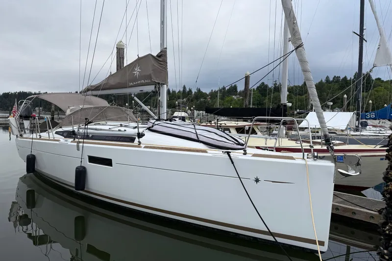 Slide: The Image of 2016 Jeanneau Sun Odyssey 349 sailboat docked in a marina, overcast sky. - 22