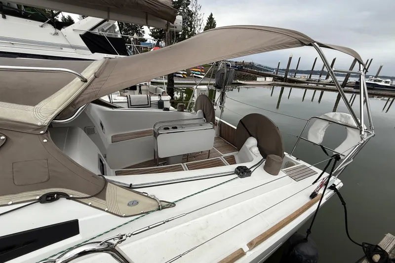 Slide: The Image of 2016 Jeanneau Sun Odyssey 349 sailboat docked at marina, featuring spacious cockpit and canopy. - 23